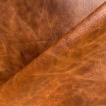 Close-up of textured brown leather with natural creases and folds.