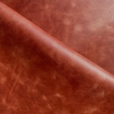 Close-up of a folded brown leather fabric with a smooth texture.
