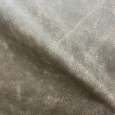 Close-up of textured gray leather fabric showing natural grain and creases.