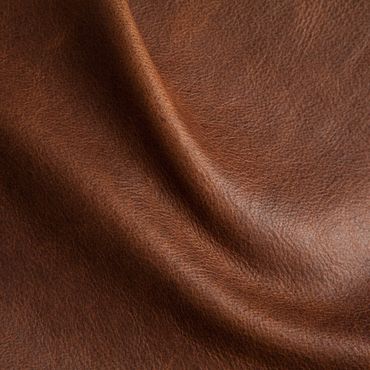 Close-up of textured brown leather fabric with natural folds.