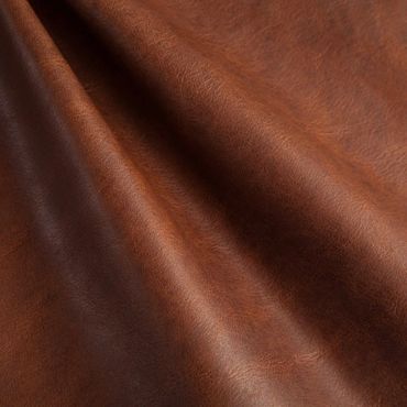 Close-up of brown leather with natural texture and folds.
