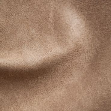 Close-up of brown leather texture with natural wrinkles and grain.