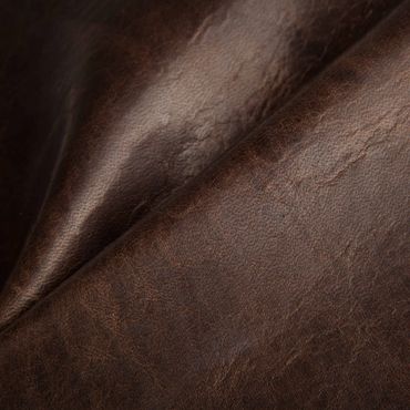 Close-up of textured brown leather fabric with natural creases.