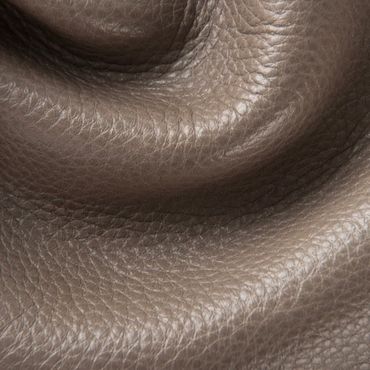 Close-up of textured brown leather surface with natural wrinkles.