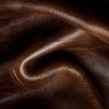 Close-up of rich brown leather with textured folds and natural grain.