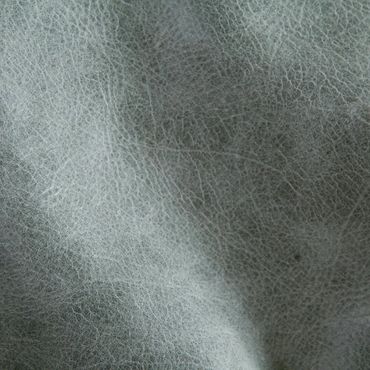 Close-up of textured gray leather surface with visible grain patterns.