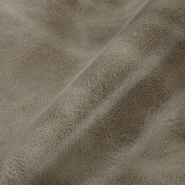 Close-up of textured brown leather fabric with natural wrinkles.
