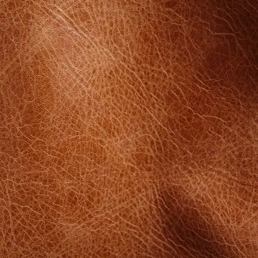 Close-up of textured brown leather surface with fine wrinkles.