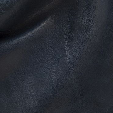 Close-up of dark textured leather material with natural creases.