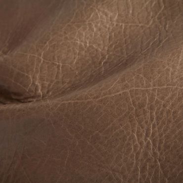 Close-up of textured brown leather surface with natural wrinkles.