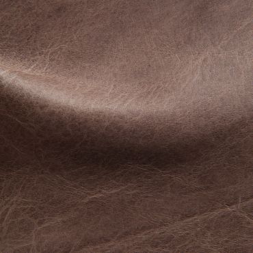 Close-up of textured brown leather surface with natural creases.
