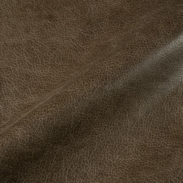 Close-up of textured brown leather surface with natural wrinkles.
