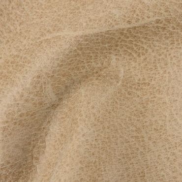 Close-up of beige textured leather material with natural wrinkles.