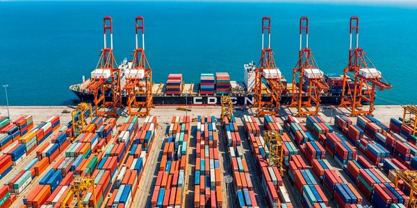 A busy shipping port with colorful containers and cranes.