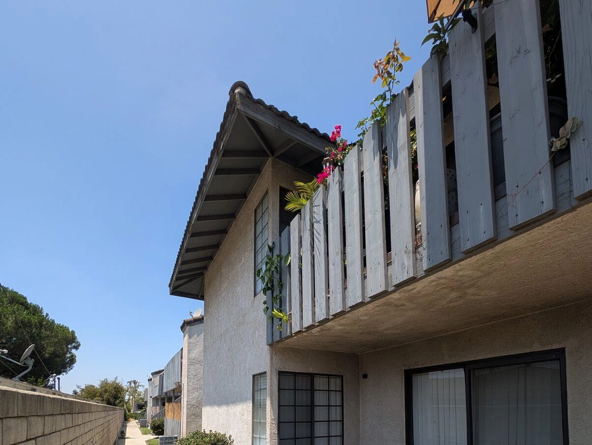Two-story apartment building with a walkway and wood railings in San Bernardino