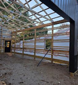 Construction site with steel framing and wooden supports inside a partially built structure.