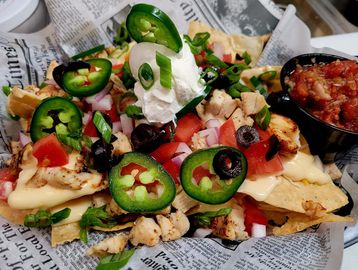 Loaded nachos with jalapeños, sour cream, and salsa.