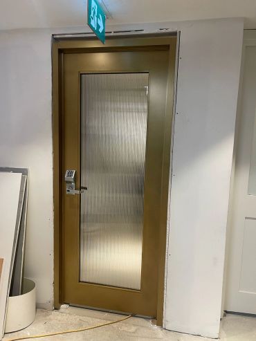 Gold Frame door with reeded glass and keypad lock.