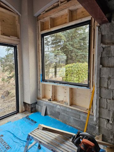 Window installation in progress with wooden framing