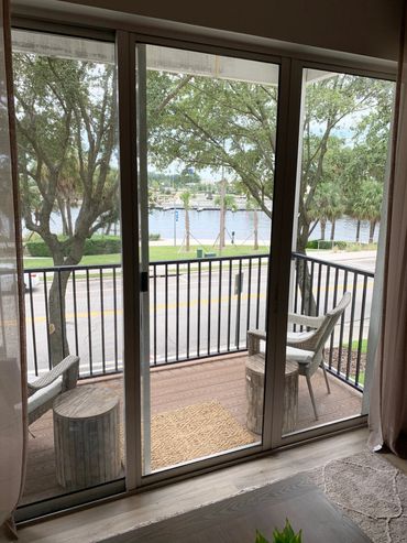 View of a balcony with chairs overlooking a street and river.