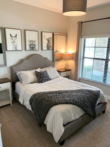 Cozy bedroom with neutral tones and animal artwork above the bed.