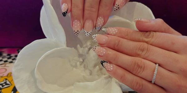 Polka dot French tip nails on a flower sculpture.