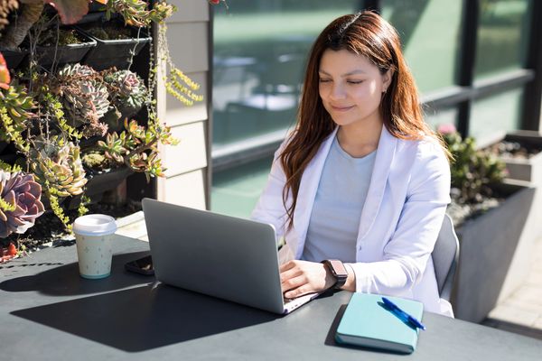 Doctora trabajando en su laptop desde una cafetería 