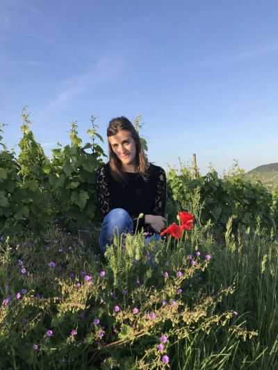 Woman sitting in a field of flowers on a sunny day.
