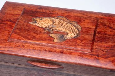 Wooden box with engraved fish design.