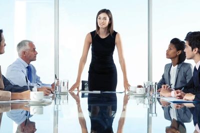 Chairwoman of a council addressing other council members in a modern council chamber.