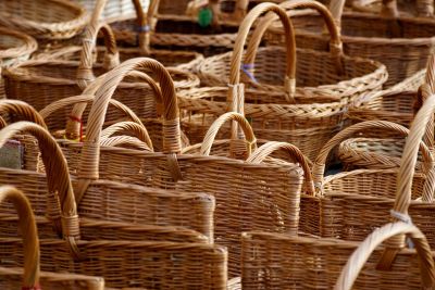 A collection of woven wicker baskets with handles.