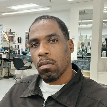 Man in a barbershop looking serious.