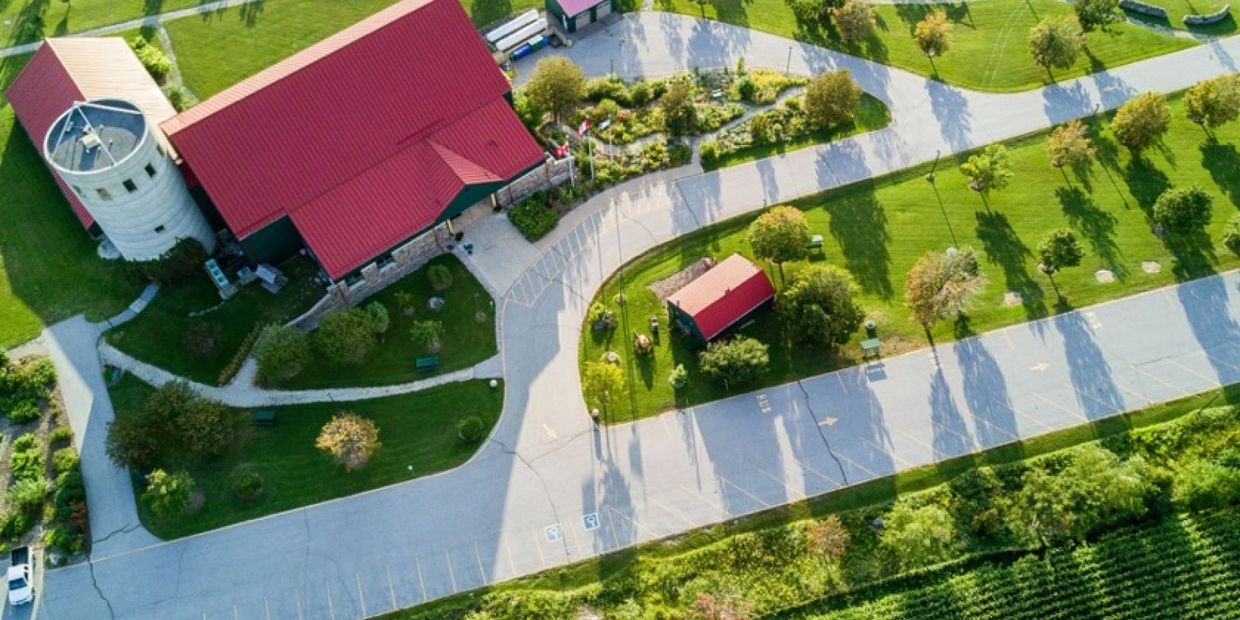 Aerial view of a farm with green fields and a red-roofed barn.