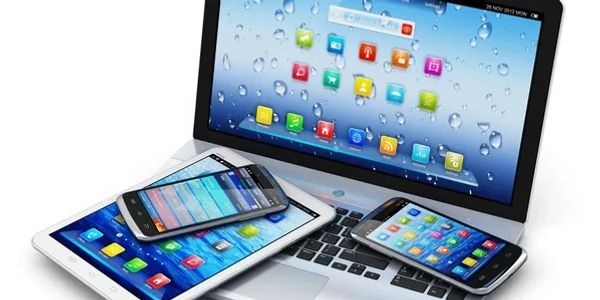 A silver laptop, two phones, and a tablet all of which can be used for telehealth psychologist