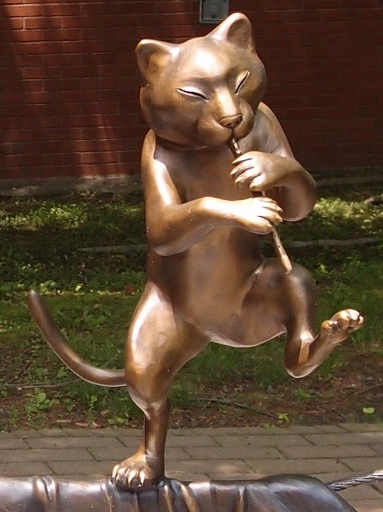 bronze cat playing a flute