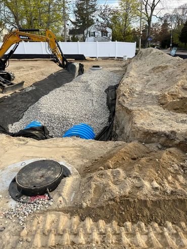 Excavation and drainage system installation in progress at a residential construction site. Shown: g