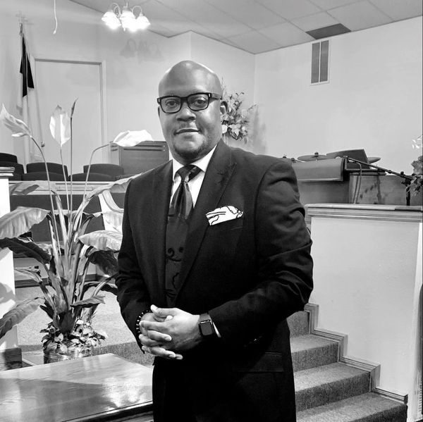 Man in a suit posing indoors.