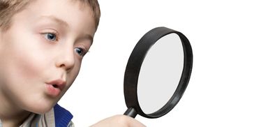 Young boy exploring with a magnifying glass.
