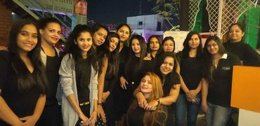 Group of women posing together at night in a casual setting.