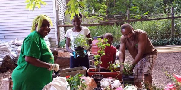 Family gardening together in a backyard.