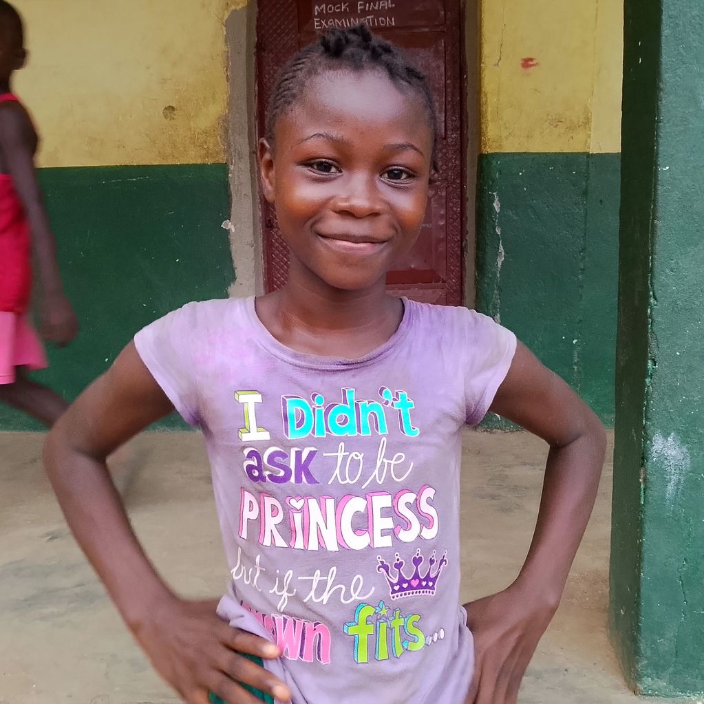 Smiling girl wearing a purple shirt with a colorful princess quote.