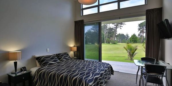 Cozy bedroom with glass sliding door opening to a green garden.