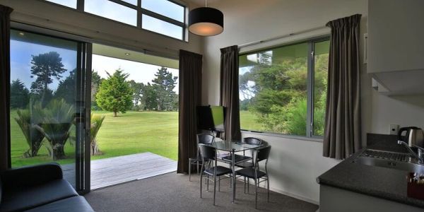 Cozy room with large windows overlooking a green lawn.
