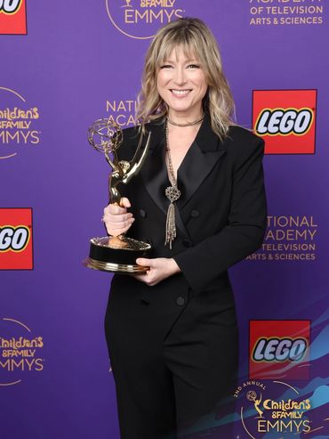 Photo of Heather Laura Gray at the C&F Emmy's holding the Emmy for Outstanding Choreography.