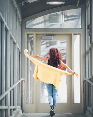 Woman walking away holding sweater with open arms