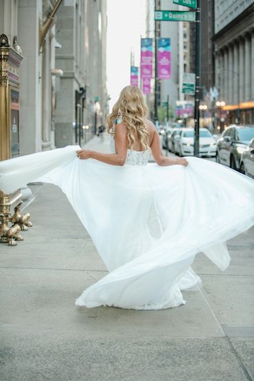 Bride spinning holding wedding gown.