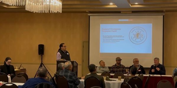 A panel discussion at a conference with a presentation on emergency response.