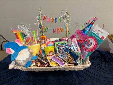 Colorful birthday gift basket with toys and treats.