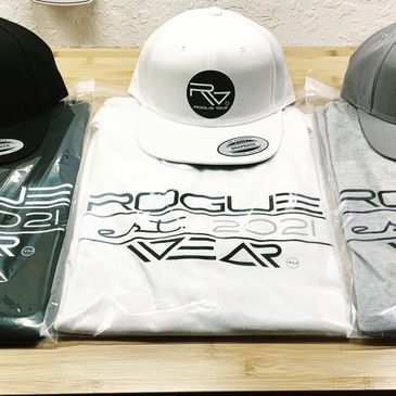 Rogue Wear hats and t-shirts on a counter.