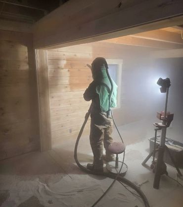 Sandblasting a log cabin